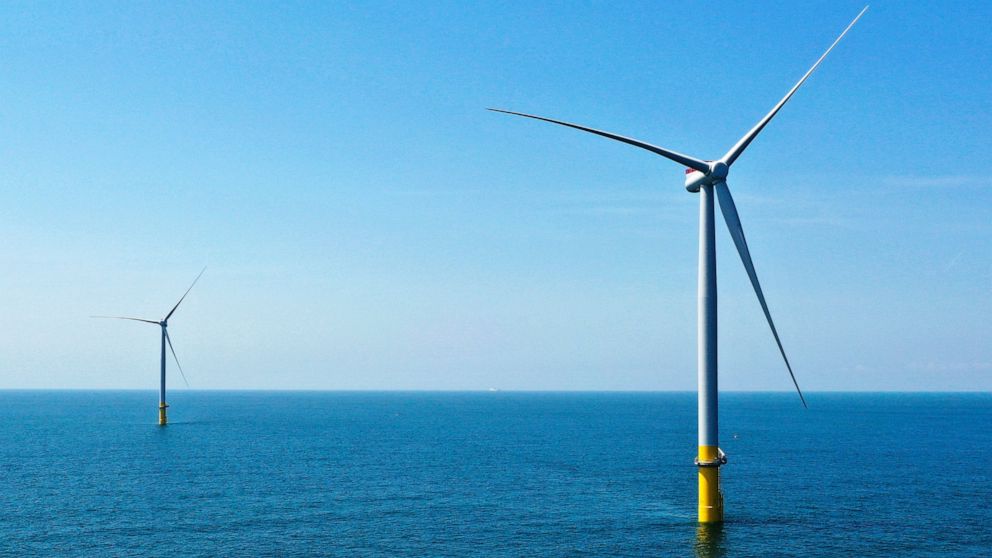 FILE - Two of the offshore wind turbines which have been constructed off the coast of Virginia Beach, Va. are viewed June 29, 2020. State regulators on Friday, Aug. 5, 2022, approved an application from Dominion Energy Virginia to build an enormous o