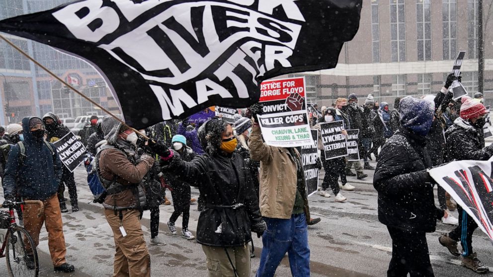 A group of protesters march in the snow around the Hennepin County Government Center, Monday, March 15, 2021, in Minneapolis where the second week of jury selection continues in the trial for former Minneapolis police officer Derek Chauvin. Chauvin i