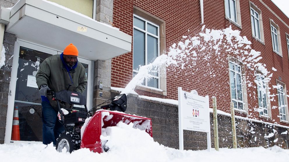A man uses a snowblower to clear the sidewalk outside the Durham Memorial A.M.E Zion Church on Friday, Nov. 18, 2022, in Buffalo, N.Y. A dangerous lake-effect snowstorm paralyzed parts of western and northern New York, with nearly 2 feet of snow alre