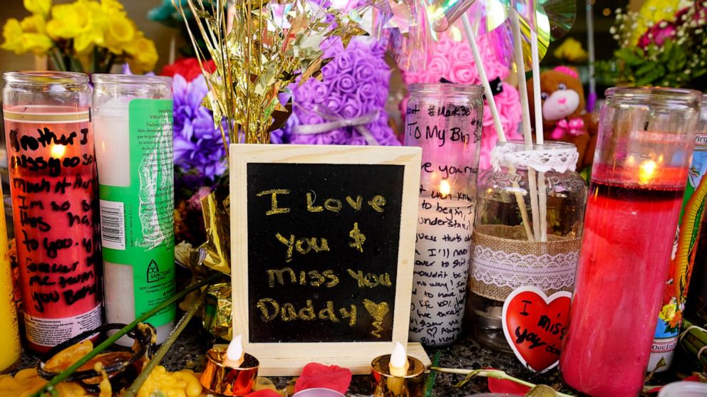 A message left for one of the victims of a recent mass shooting sits among flowers and candles at a memorial in Sacramento, Calif., Saturday, April 9, 2022. The April 3 shooting, which left six dead and 12 wounded, occurred near the state Capitol, an