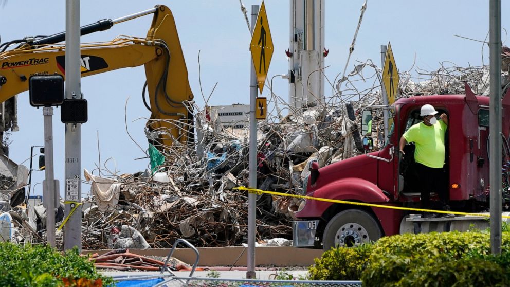 A worker waits to load his truck with debris from the rubble of the Champlain Towers South building, as removal and recovery work continues at the site of the partially collapsed condo building, Wednesday, July 14, 2021, in Surfside, Fla. (AP Photo/L