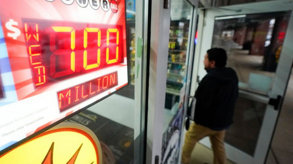 FILE - A patron enters a liquor store as a sign displays the Powerball jackpot, Tuesday, Oct. 25, 2022, in Baltimore. No one won an estimated $700 million Powerball jackpot Wednesday night, meaning the big prize will grow to an estimated $800 million