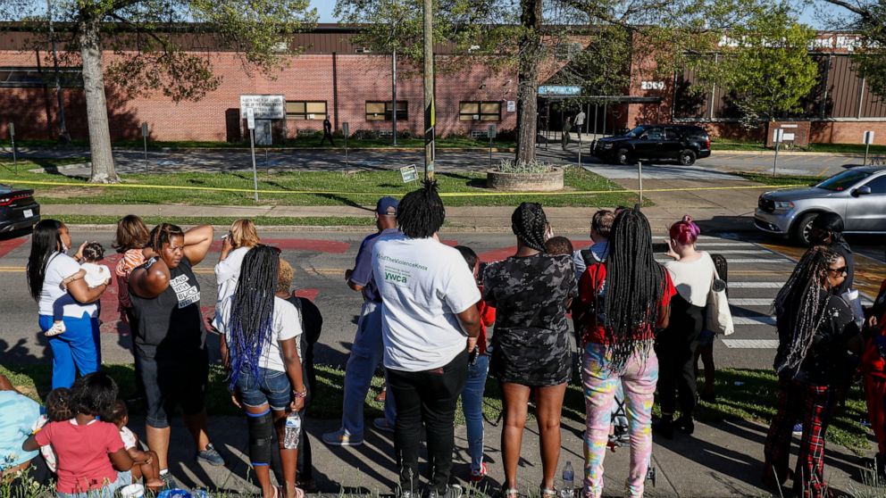People look on as Knoxville police work the scene of a shooting at Austin-East Magnet High School Monday, April 12, 2021, in Knoxville, Tenn. (AP Photo/Wade Payne)