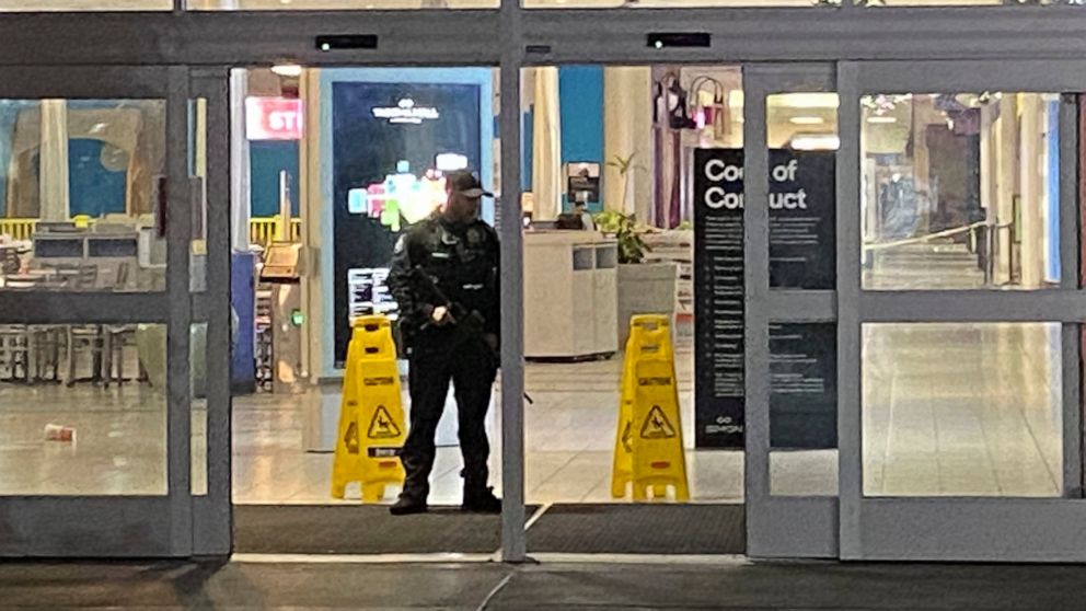 An officer guards an entrance to the Tacoma Mall, late Friday, Nov. 26, 2021, in Tacoma, Wash. Gunshots rang out in the shopping center earlier in the evening with one person being shot. (Craig Sailor/The News Tribune via AP)