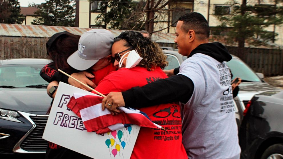 George DeJesus is embraced by family and supporters at a restaurant parking lot Tuesday March 22, 2022, in Lansing, Mich. George and his brother Melvin DeJesus had their two decades old wrongful conviction thrown out by an Oakland County Judge Tuesda