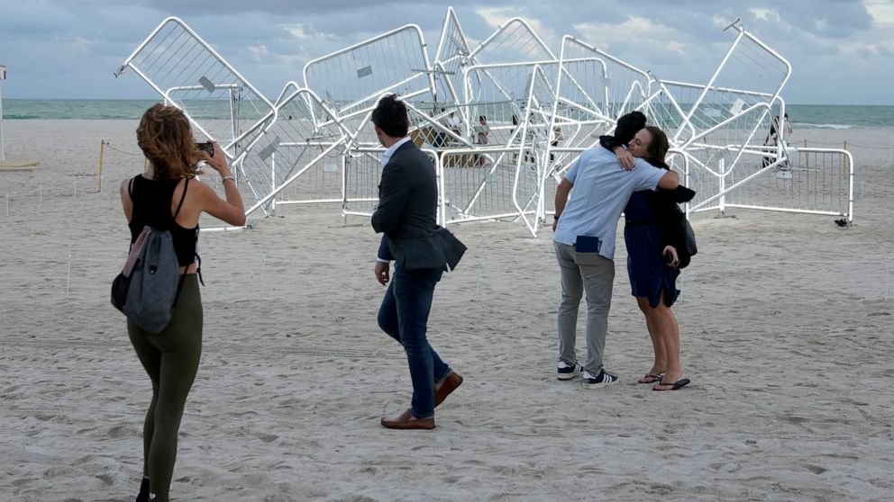 People walk past a light sculpture titled Patria y Vida created by Cuban-American artists Ruben Millares and Antonia Wright, during Miami Art Week, Thursday, Dec. 1, 2022, in Miami Beach, Fla. The sculpture is named for the anti-communism protests in