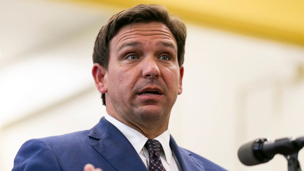 FILE - This May 4 2021 file photo shows Florida Gov. Ron DeSantis, center, speaks during a news conference at West Miami Middle School in Miami. Several states scaled back their reporting of COVID-19 statistics this July 2021, just as cases across th