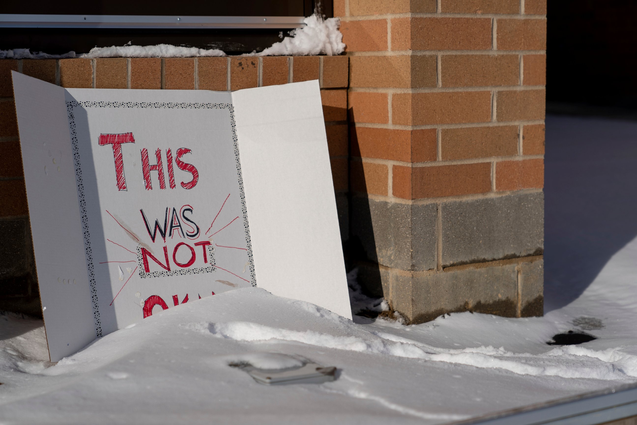 A sign reading "This was not okay," is seen in front of Covington Catholic High School in Park Kills, Ky., Sunday, Jan 20, 2019. A diocese in Kentucky has apologized after videos emerged showing students from the Catholic boys' high school mocking Na