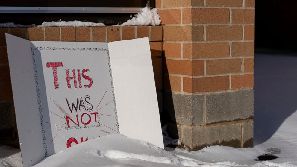 A sign reading "This was not okay," is seen in front of Covington Catholic High School in Park Kills, Ky., Sunday, Jan 20, 2019. A diocese in Kentucky has apologized after videos emerged showing students from the Catholic boys' high school mocking Na