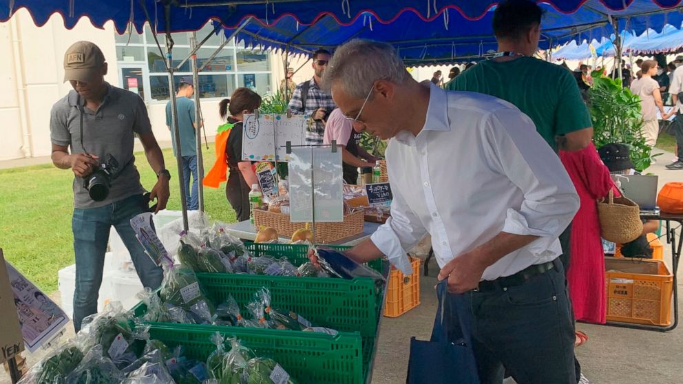 U.S. Ambassador to Japan Rahm Emanuel looks at vegetables at the farmers market at Camp Hansen, a U.S. Marine Corps base on a southern Japanese island of Okinawa, Sunday, Oct. 30, 2022. (U.S. Embassy via AP)