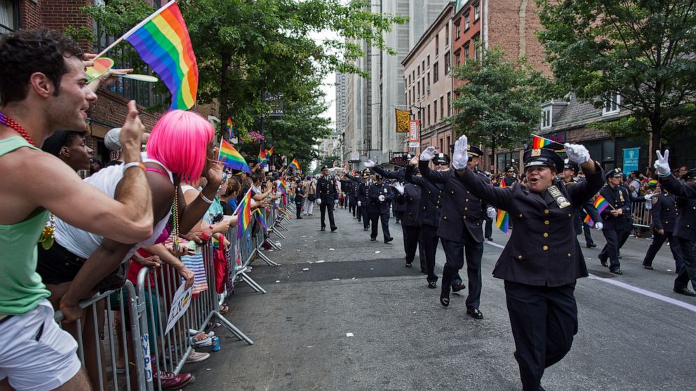 FILE - In this Sunday, June 30, 2013 file photo, Members of the Gay Officers Action League of the New York police department are cheered during the gay pride march in New York. As Pride weekend approaches, the recent decision by organizers of New Yor
