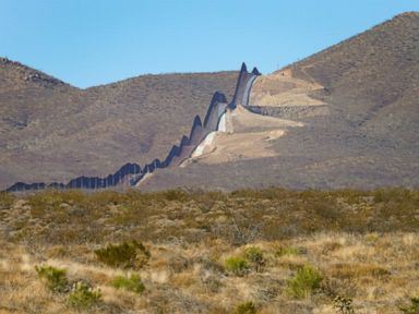 Autopsy: Woman migrant found on border wall choked to death