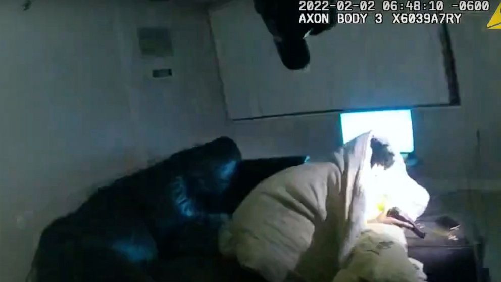 In this image taken from Minneapolis Police Department body camera video and released by the city of Minneapolis, 22-year-old Amir Locke wrapped in a blanket on a couch holding a gun moments before he was fatally shot by Minneapolis police as they we