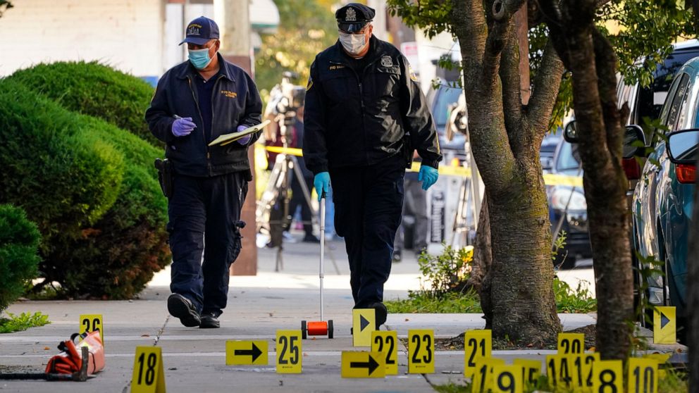Investigators work the scene where multiple people were shot including police officers when a SWAT team attempted to serve a homicide warrant in Philadelphia, Wednesday, Oct. 12, 2022. The shooting occurred around 6:30 a.m., soon after officers tried
