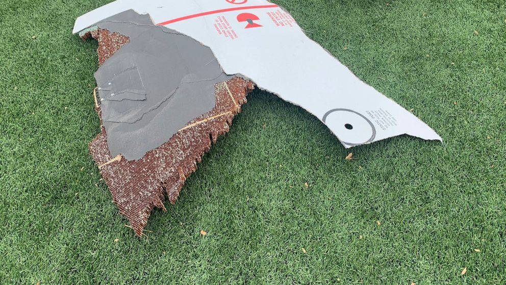 In this photo provided by the Broomfield Police Department on Twitter, debris is scattered across turf field at Commons Park, Saturday, Feb. 20, 2021, in Broomfield, Colo. The police ask that the area be avoided if possible. A commercial airliner dro