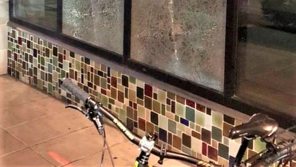 FILE- This March 12, 2021, file photo released by Portland Police Bureau shows smashed windows left behind by people inside the perimeter of a march by a group of about 100 hundred protesters Friday night in Portland, Ore. Portland Mayor Wheeler on M