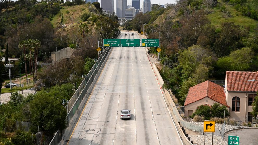 FILE— Light traffic moves along the Arroyo Seco Parkway toward downtown Los Angeles, March 31, 2020, in Los Angeles. California's climate emissions dropped by nearly 9% in 2020 compared to the year before as the coronavirus pandemic kept people at ho