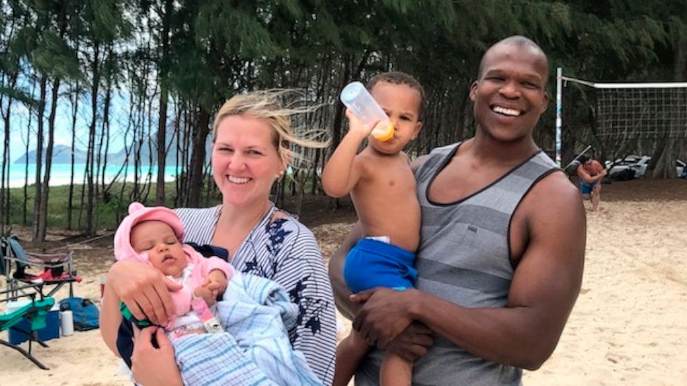In a 2021 photo provided by Bickerton Law Group representing the family of Lindani Myeni, he is standing on a beach in Waimanalo, Hawaii with his wife and two children. Some Black people in Hawaii say Myeni's shooting death by Honolulu police is a re