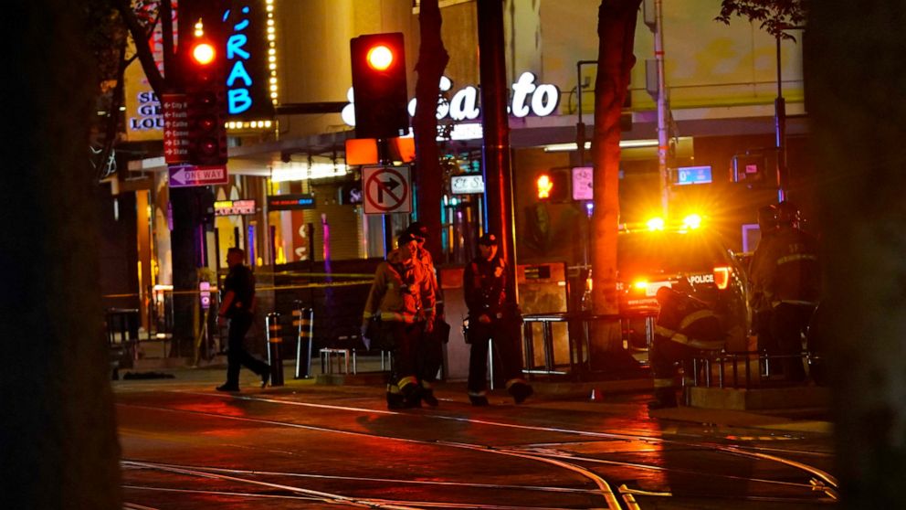 Emergency workers walk in downtown Sacramento, Calif., after an apparent mass shooting Sunday, April 3, 2022. (AP Photo/Rich Pedroncelli)