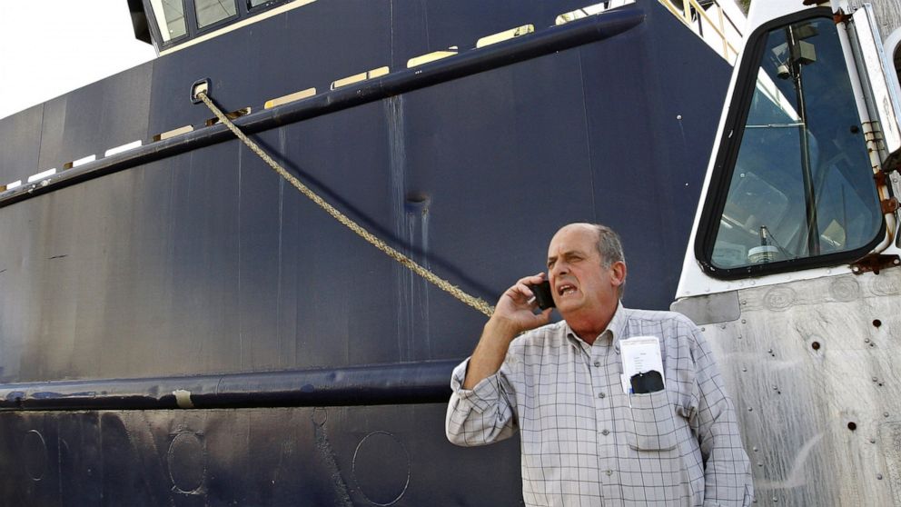 FILE - In this Oct. 14, 2014, file photo, Carlos Rafael talks on the phone at Homer's Wharf near his herring boat F/V Voyager in New Bedford, Mass. A Massachusetts company is slated to acquire in 2020 what's left of the boats once owned by Rafael, wh