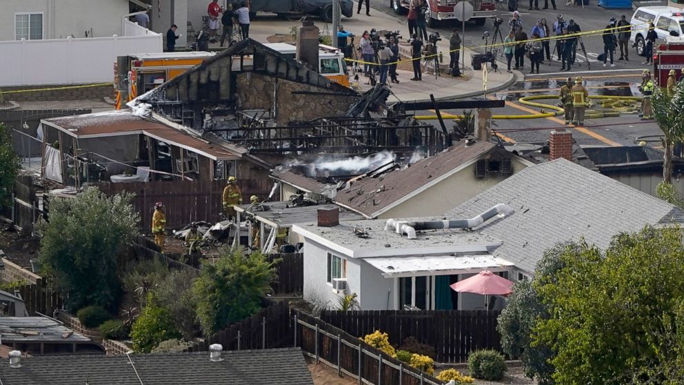 Emergency crews work a the scene of a small plane crash, Monday, Oct. 11, 2021, in Santee, Calif. Authorities say at least two people were killed and two others were injured when the plane crashed into a suburban Southern California neighborhood, set