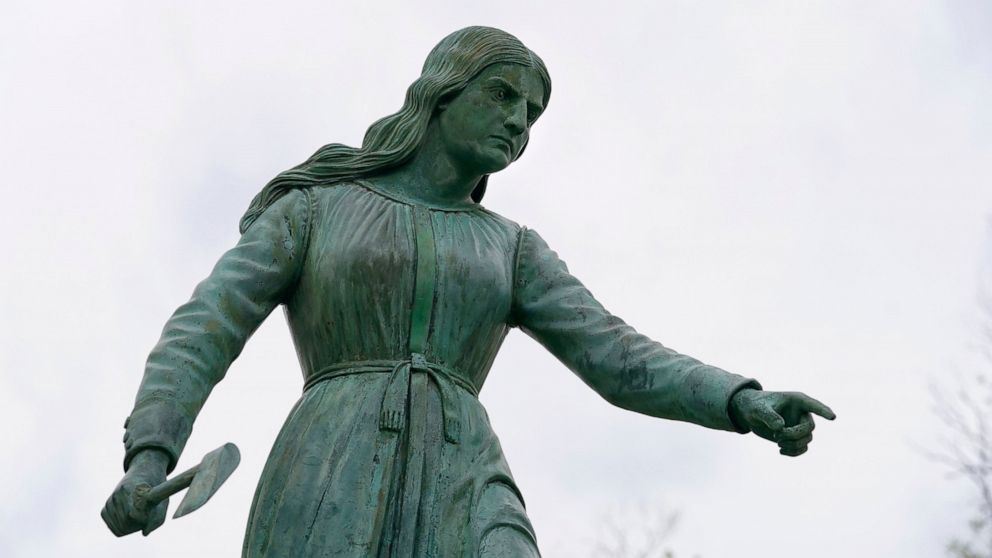A statue of Hannah Duston, dated 1879, stands in the Grand Army of the Republic Park, Wednesday, April 28, 2021, in Haverhill, Mass., meant to honor the English colonist who, legend has it, slaughtered her Native American captors after the gruesome k