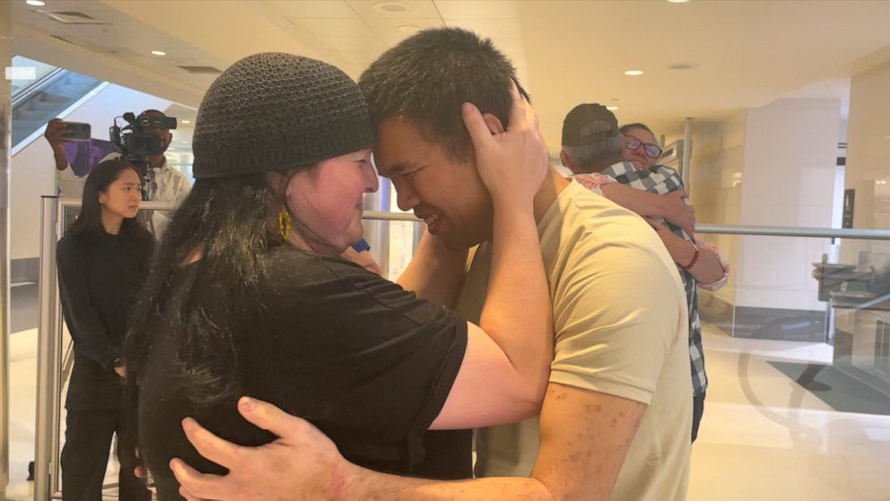 Andy Huynh, left, and Alex Drueke, far right, are seen hugging their loved ones after arriving at Birmingham-Shuttlesworth International Airport in Birmingham, Ala., Saturday, Sept. 24, 2022. The U.S. military veterans disappeared three months ago wh