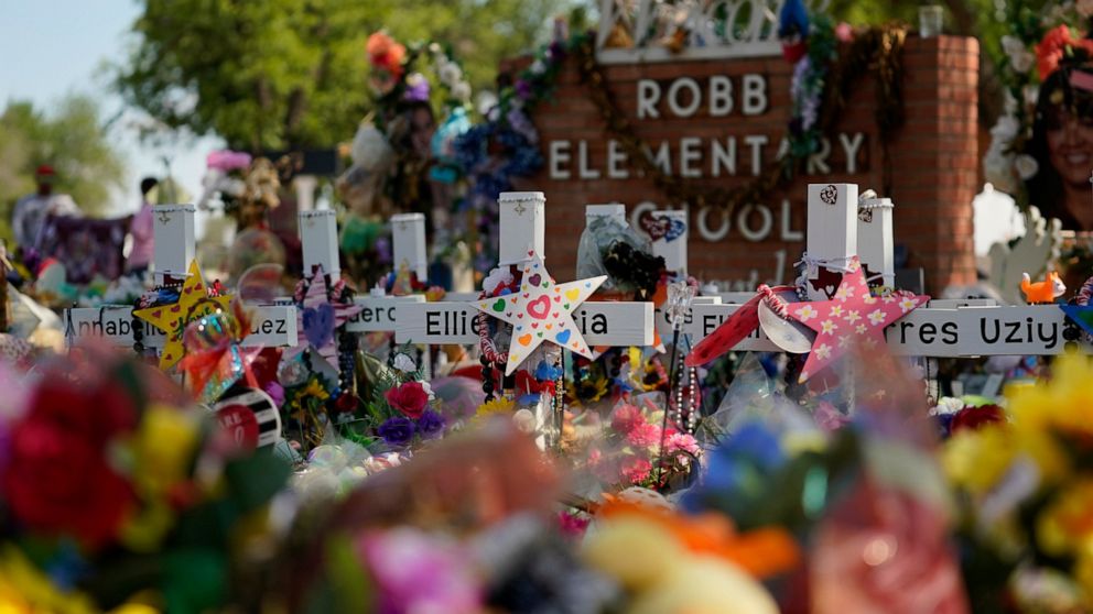 FILE - Crosses, flowers and other memorabilia form a make-shift memorial for the victims of the shootings at Robb Elementary School in Uvalde, Texas, July 10, 2022. The Associated Press and other news organizations are suing officials in Uvalde after