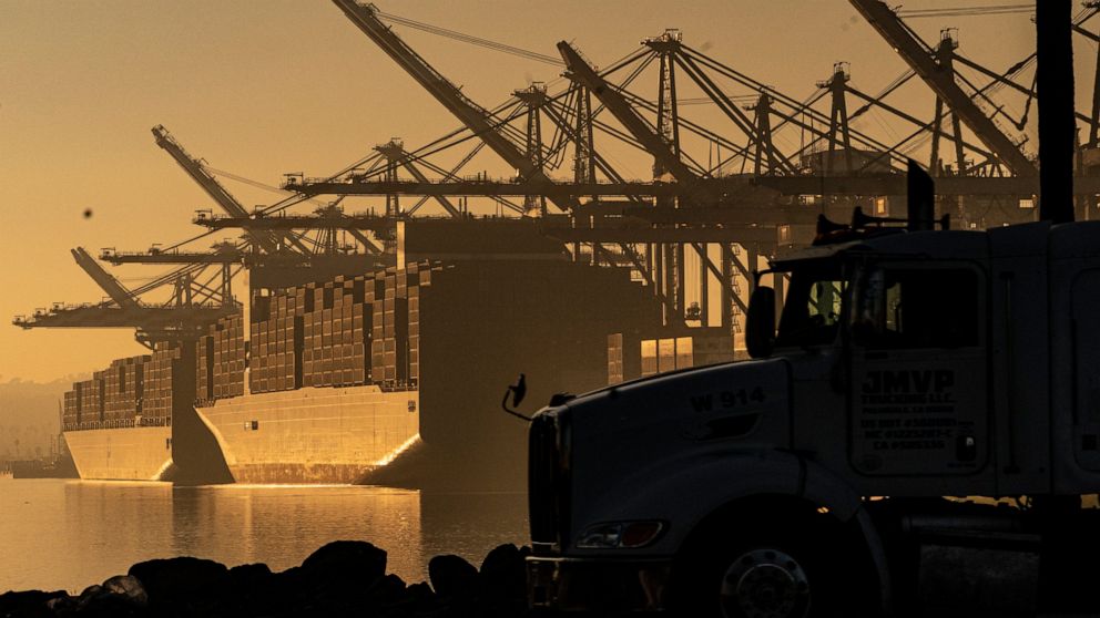 FILE - A truck arrives to pick up a shipping container near vessels moored at Maersk APM Terminals Pacific at the Port of Los Angeles, on Nov. 30, 2021. Contract negotiations between 22,000 workers at 29 West Coast ports and representatives of shippi