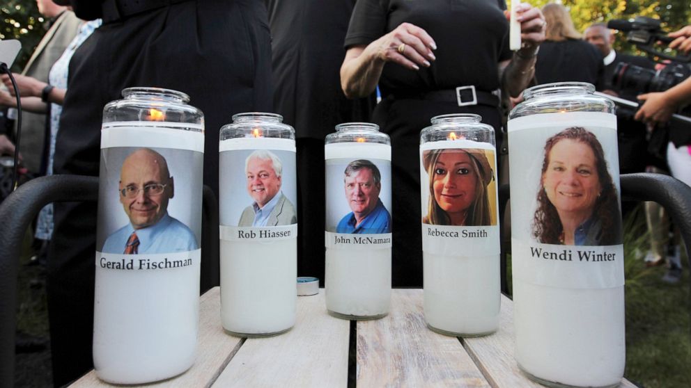 FILE - In this June 29, 2018, file photo, pictures of five employees of the Capital Gazette newspaper adorn candles during a vigil across the street from where they were slain in the newsroom in Annapolis, Md. A jury was selected on Friday, June 25, 