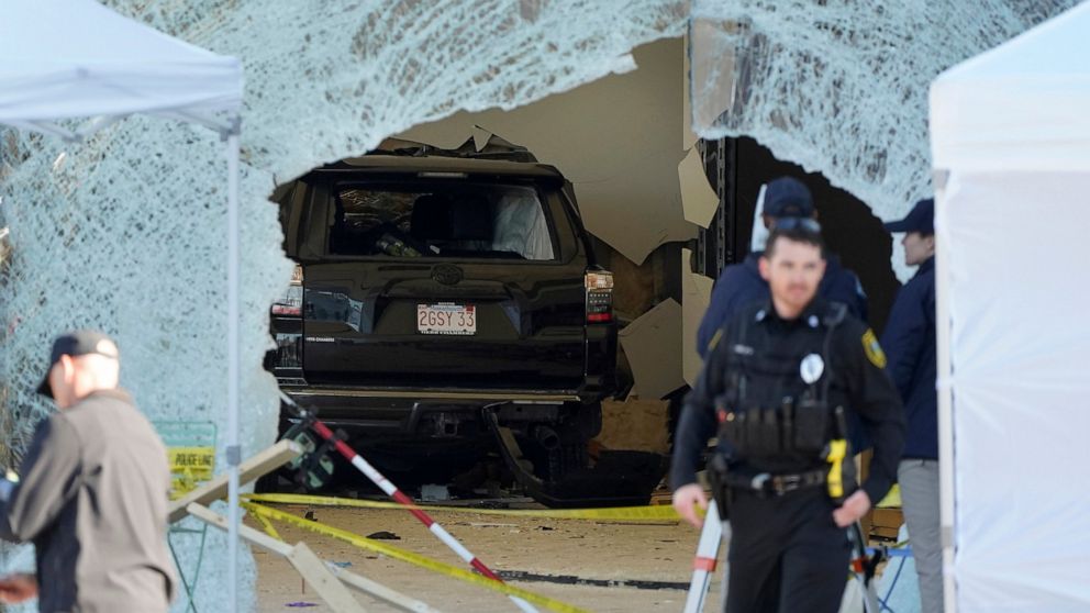 FILE - An SUV rests inside an Apple store behind a large hole in the glass front of the store on Nov. 21, 2022, in Hingham, Mass. The family of a man who was badly hurt when an SUV crashed into an Apple store in Massachusetts, killing one person and 