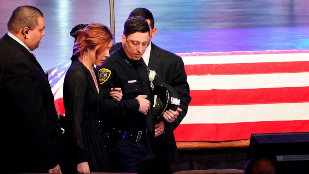 Widow Bethany Elise Brewster is escorted into the church sanctuary for the funeral of her husband, Houston Police Sgt. Christopher Brewster, Thursday, Dec. 12, 2019, at Grace Church Houston in Houston. Brewster, 32, was gunned down Saturday evening, 