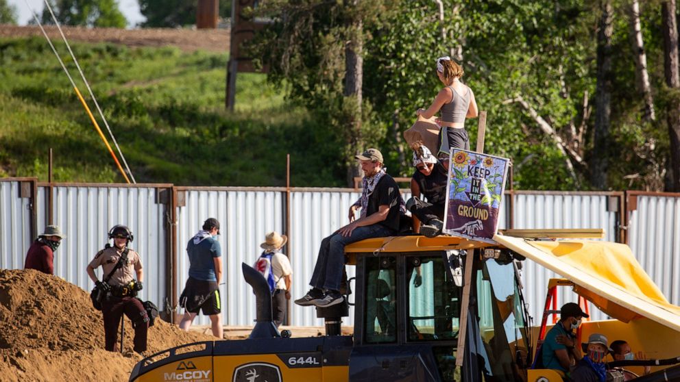 Activists sit on construction equipment while others are arrested and escorted out of an Enbridge Line 3 pump station near Park Rapids, Minn., on Monday, June 7, 2021. (Evan Frost/Minnesota Public Radio via AP)