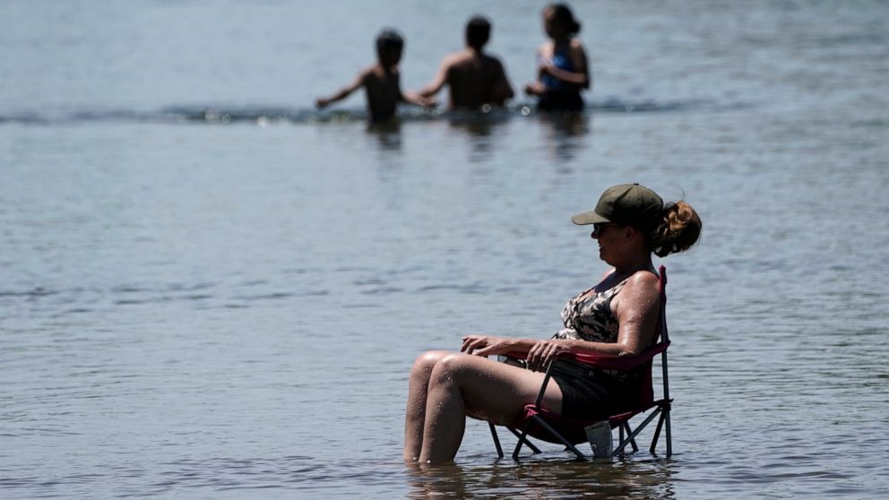 Dianna Andaya, relaxes in the cooling water of the American River as the temperature climbed over the 100 degree mark in Sacramento, Calif., Friday, June 10, 2022. Forecasters are warning of dangerously high temperatures in much of the interior of Ca