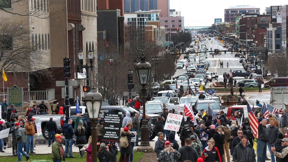 Protesters gather at the Michigan State Capitol in Lansing, Mich., Wednesday, April 15, 2020. Flag-waving, honking protesters drove past the Michigan Capitol on Wednesday to show their displeasure with Gov. Gretchen Whitmer's orders to keep people at