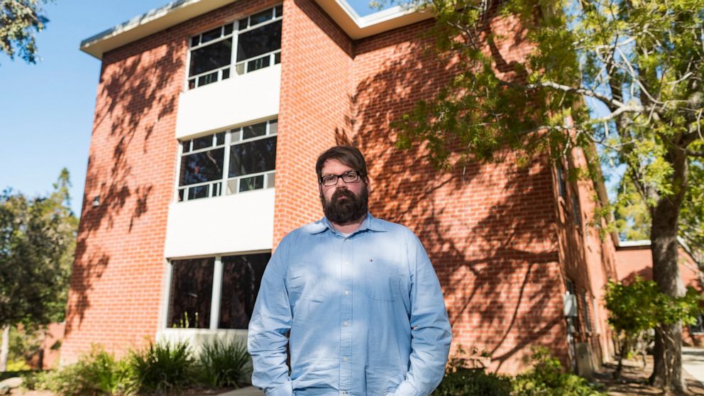 Chris Lambert, a musician and recording engineer, poses Thursday, April 15, 2021, in front of Muir Hall dormitory at California Polytechnic University in San Luis Obispo, Calif. Lambert started a podcast to document the 1996 disappearance of Kristin 