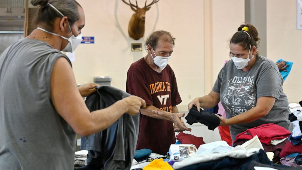 Evacuees of the flooding in eastern Kentucky gather clothing at the Knott County Sportsplex in Leburn, Ky., Friday, July 29, 2022. The sportsplex is being used as an emergency shelter, providing food, clothing, and a place to stay for those displaced