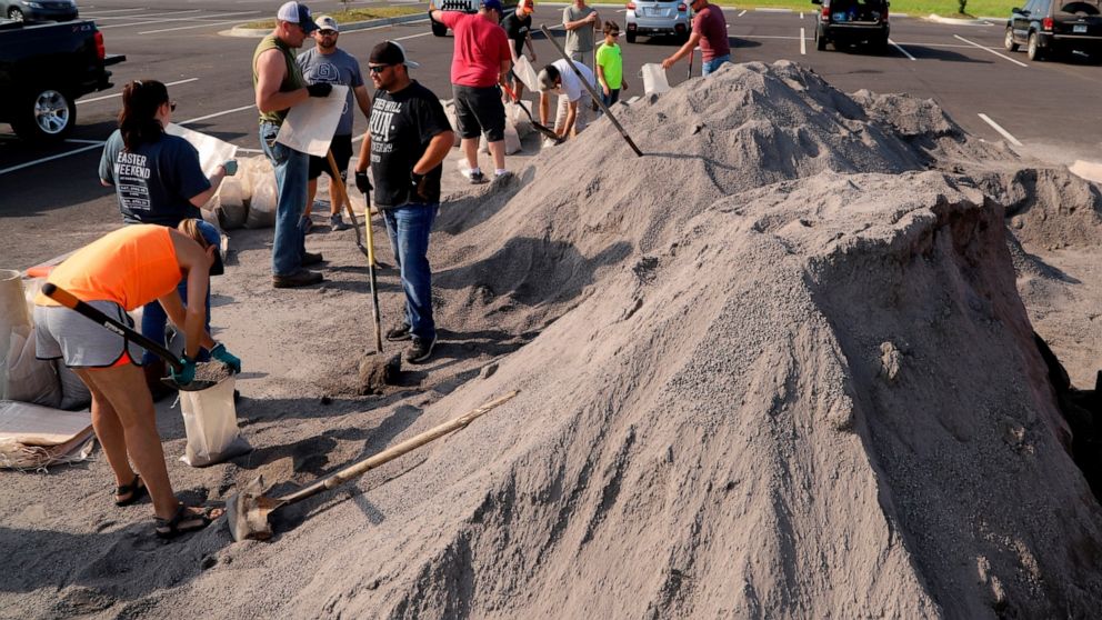 Volunteers fill sand bags at the soccer field parking lot in Chaffee Crossing, Ark., Saturday, May 25, 2019, for distribution throughout the area for flood prone areas around homes. (Jamie Mitchell/The Southwest Times Record via AP)