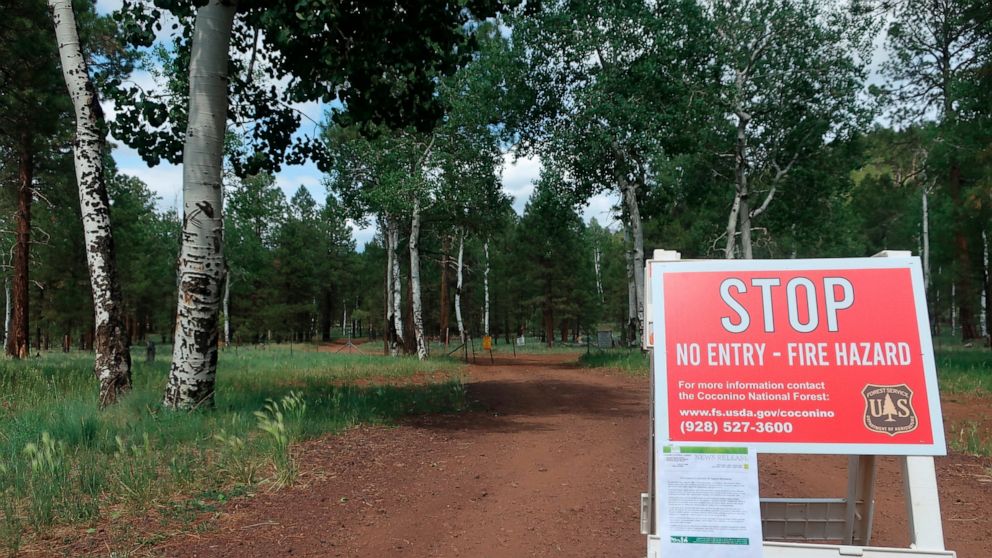 A sign posted ahead of a forest road announces the closure of the national forest surrounding Flagstaff, Ariz., on Wednesday June 23, 2021. The Coconino National Forest is one of a handful of forests in Arizona that closed this week amid high fire da