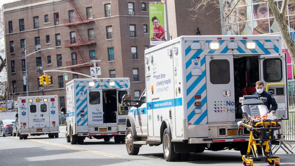 Ambulances line the street outside Elmhurst Hospital Center, Saturday, April 4, 2020 in the Queens borough of New York. The new coronavirus causes mild or moderate symptoms for most people, but for some, especially older adults and people with existi