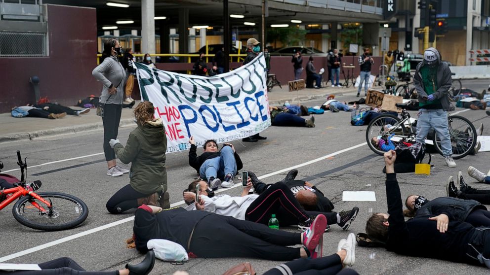 Protesters hold a die-in outside the Hennepin County Family Justice Center where four former Minneapolis police officers appeared at a hearing Friday, Sept. 11, 2020, in Minneapolis. The officers are charged in the death of George Floyd who died in p