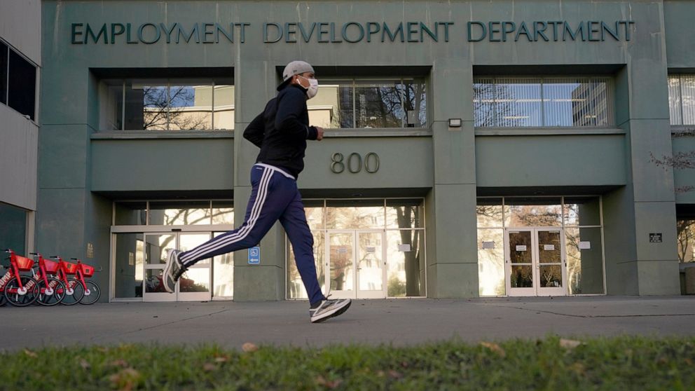 FILE - In his Dec. 18, 2020, file photo a runner passes the office of the California Employment Development Department in Sacramento, Calif. California lawmakers on Thursday, April 8, 2021, advanced what they called commonsense legislation requiring 