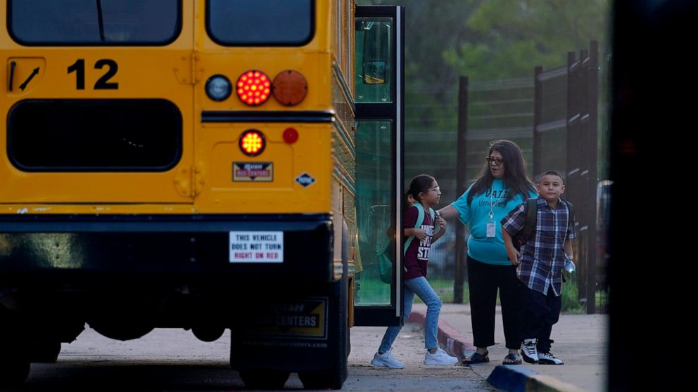 Students arrive at Uvalde Elementary, now protected by a fence and Texas State Troopers, for the first day of school, Tuesday, Sept. 6, 2022, in Uvalde. Students in Uvalde are returning to campuses for the first time since the shootings at Robb Eleme