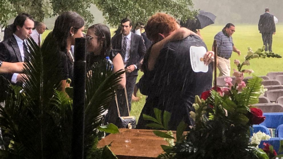 Buster Murdaugh, center, receives a hug in the rain during the funeral service for his brother, Paul, and mother, Maggie, on Friday, June 11, 2021 in Hampton, S.C. State police say information gathered by agents investigating the death of the mother 