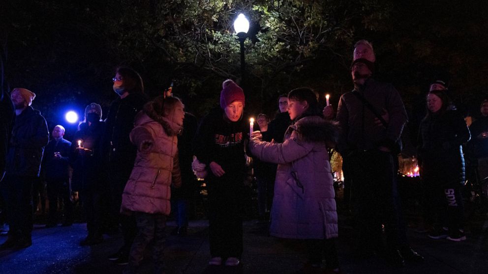 The Davanzo family, of Arlington, Va., shares a candle during a candlelight vigil held in Dupont Circle, Monday, Nov. 21, 2022, in Washington, in memory of the victims of a gunman who opened fire with a semiautomatic rifle inside a gay nightclub in C