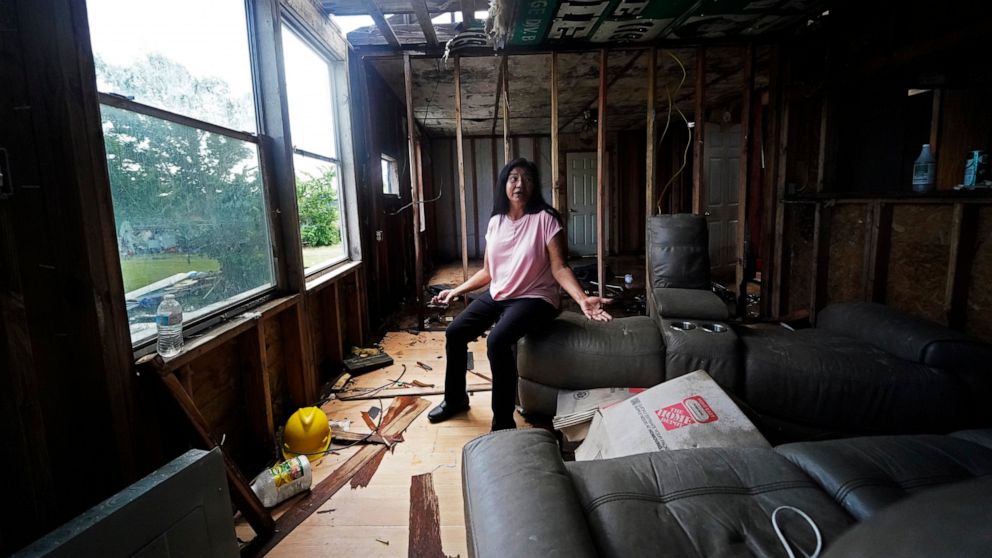 Louise Billiot, a member of the United Houma Nation Indian tribe, talks inside the home of her friend Irene Verdin, which was heavily damaged from Hurricane Ida nine months before, along Bayou Pointe-au-Chien, La., Thursday, May 26, 2022. (AP Photo/G