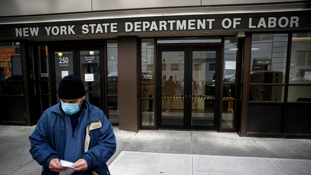 FILE - In this Wednesday, March 18, 2020 file photo, Visitors to the Department of Labor are turned away at the door by personnel due to closures over coronavirus concerns in New York. Americans are seeking unemployment benefits at unprecedented leve