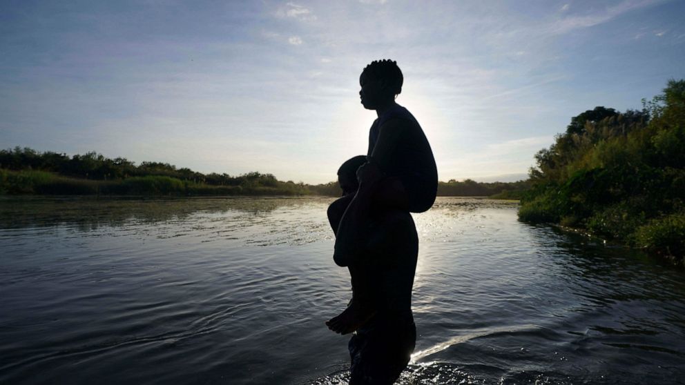 FILE - A father carries his daughter over the Rio Grande river toward Del Rio, Texas, from Ciudad Acuna, Mexico, Sept. 22, 2021. A Texas National Guard member who drowned on the U.S.-Mexico border was not wearing a flotation device, and had not been 