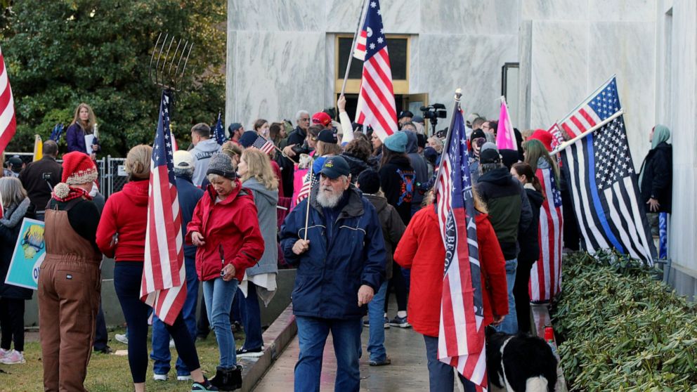 FILE - In this Dec. 21, 2020, file photo, pro-Trump and anti-mask demonstrators hold a rally outside the Oregon State Capitol as legislators meet for an emergency session in Salem, Ore. During the protest Republican lawmaker, Rep. Mike Nearman, physi