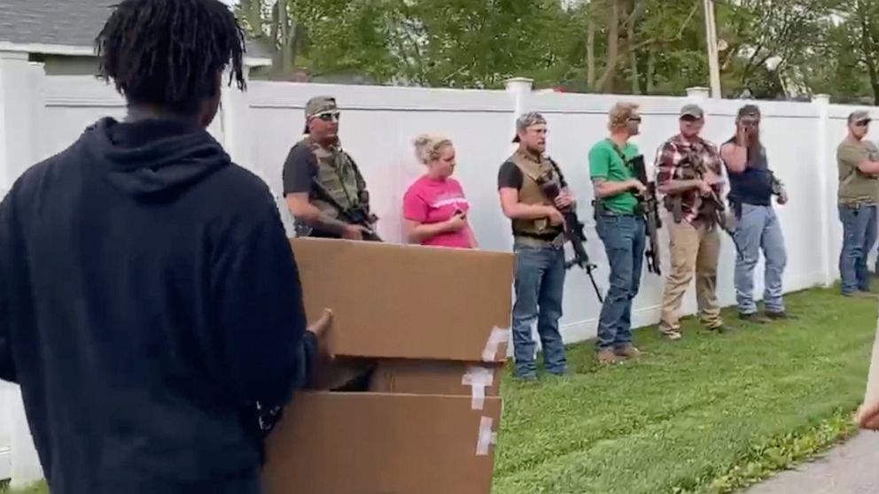 This June, 1, 2020, image from video provided by Alissa Murray shows demonstrators protesting police brutality and racism encountering a line of armed bystanders as they march in Crown Point, Ind. Crown Point Police Chief Pete Land said the armed bys